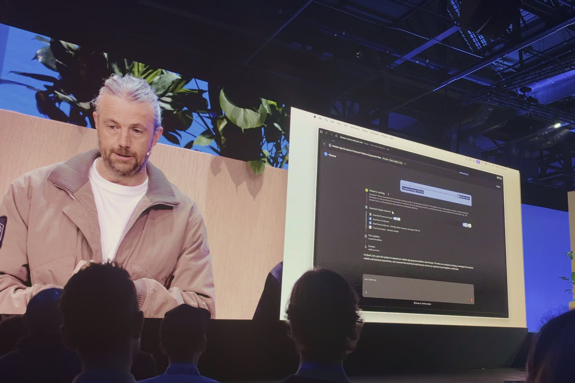 Speaker on stage at the Atlassian Team ’26 Europe founder keynote, with a product demo on the big screen